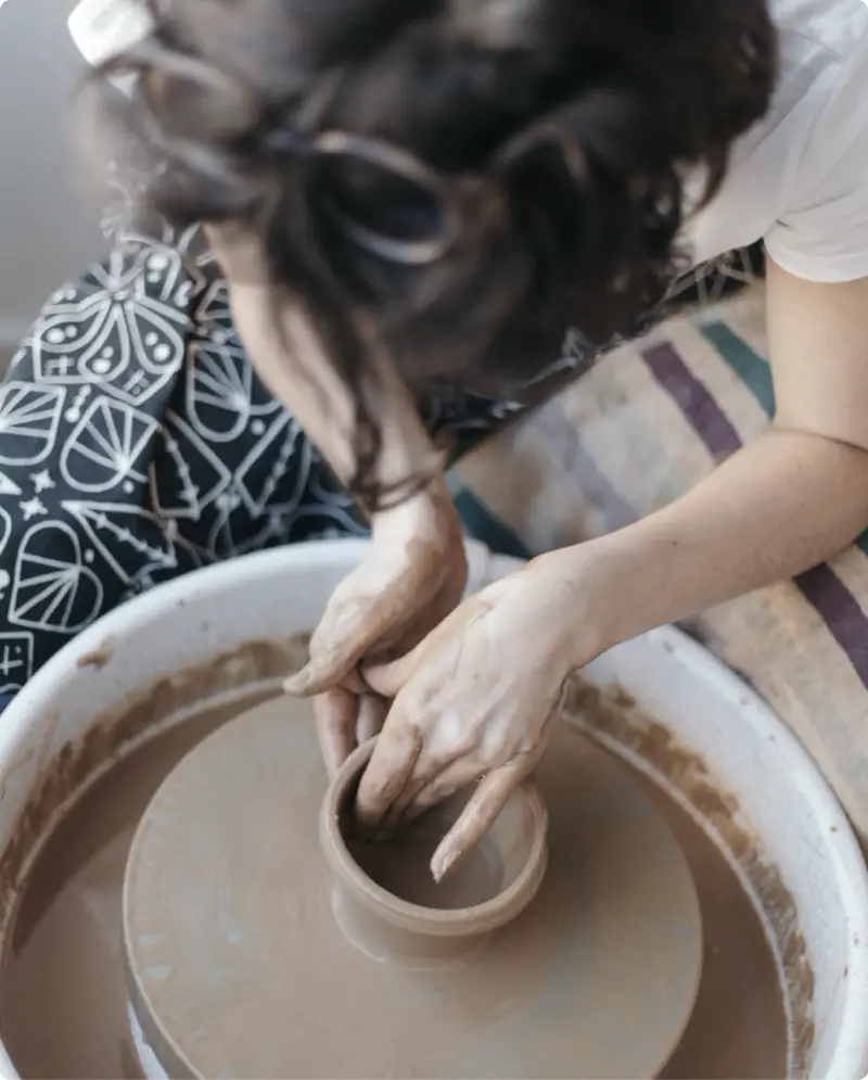 Woman making a ceramic bowl on a spinning wheel